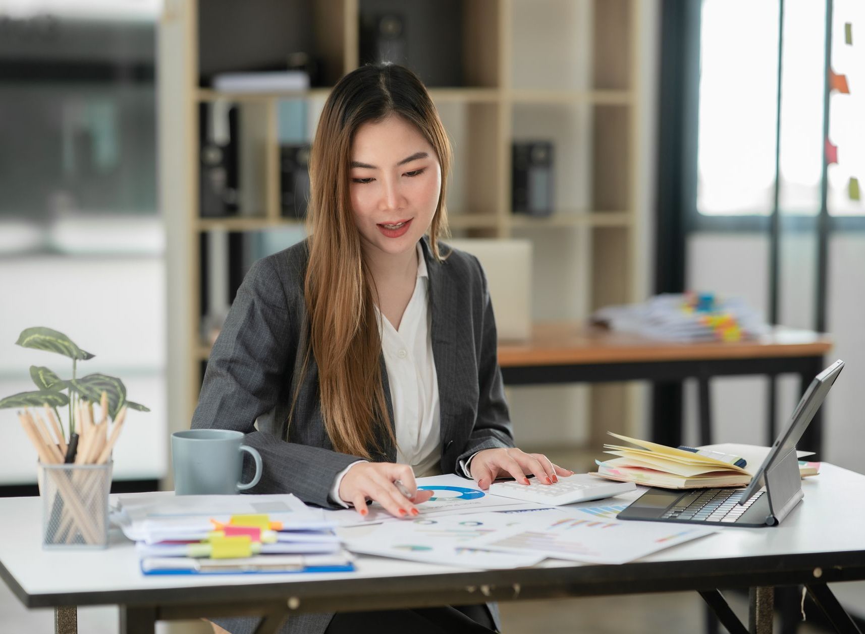 A young Asian-American court runner works at her desk and is trying to work with the new DOB redactions in California.