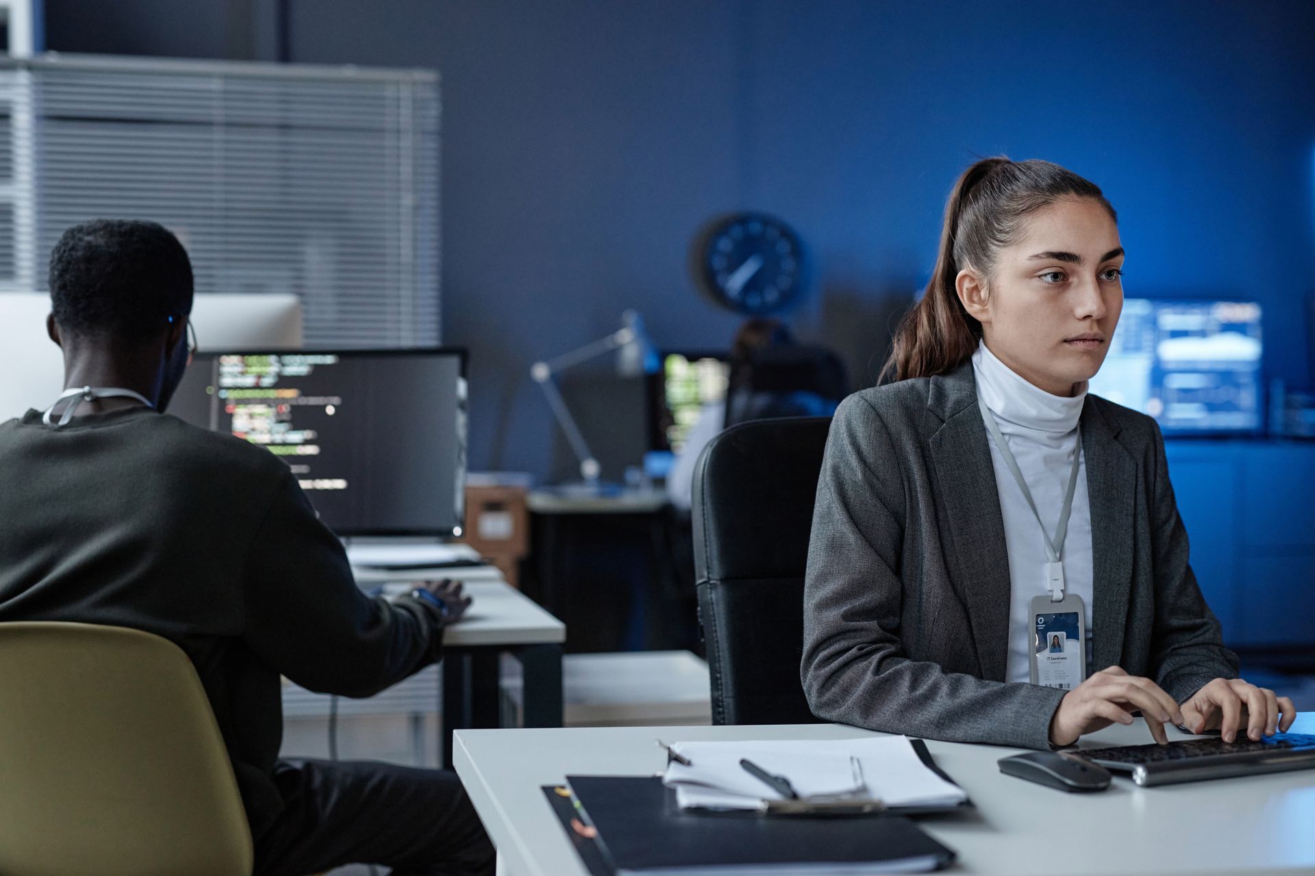 A man and a woman are sitting at a desk in front of a computer researching cybersecurity requirements for CRAs