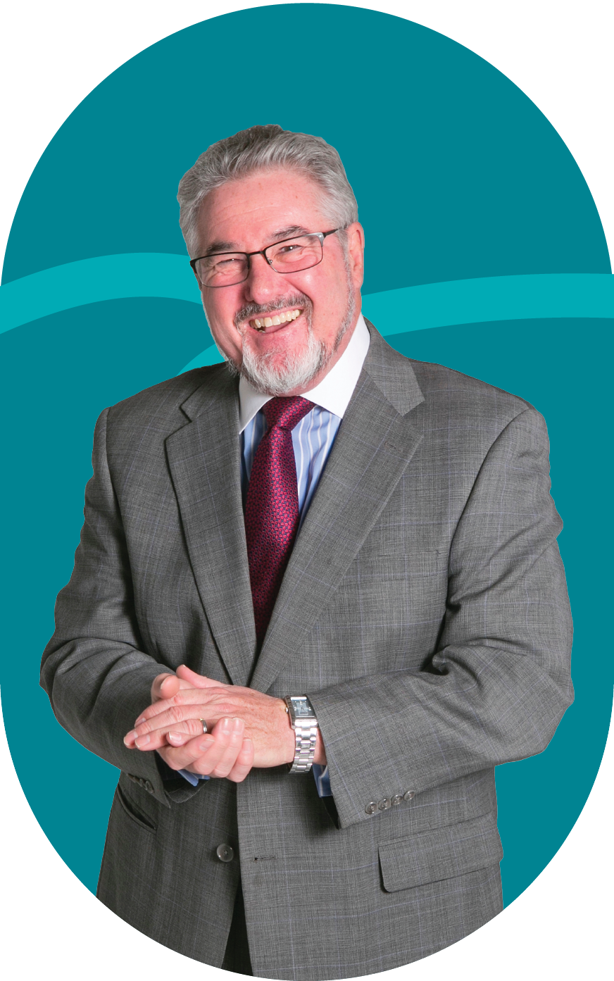 A man in a suit and tie is smiling with his hands folded