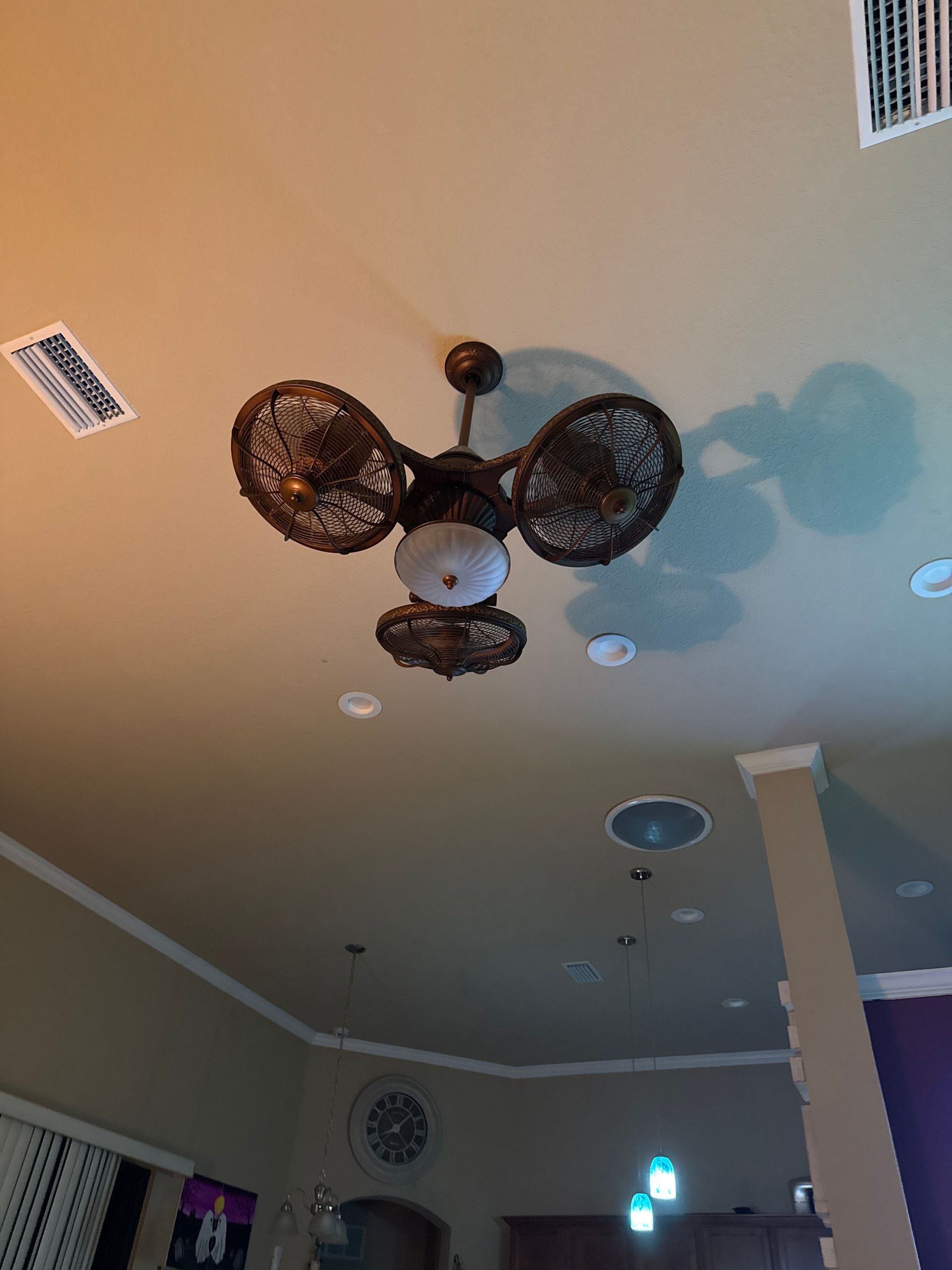 Ceiling with decorative fan/light fixture in a room with recessed lights and a column