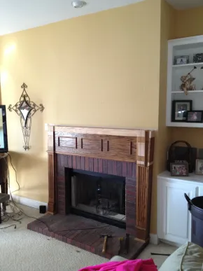 Living room with brick fireplace, yellow walls, built-in shelves, and a TV on the left