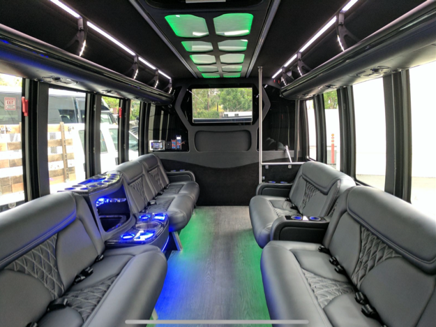 A white bus is parked in a parking lot with the door open.
