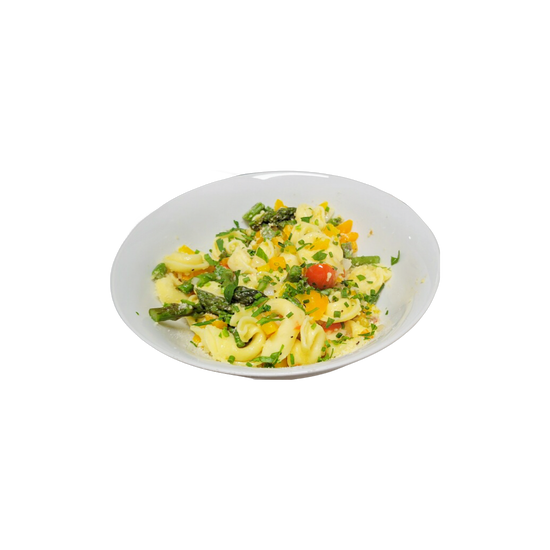 Pasta salad with asparagus, tomatoes, and herbs in a white bowl.