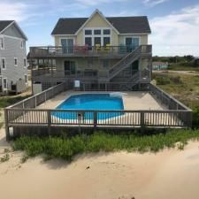 Beach house with elevated deck and fenced backyard pool beside the dunes