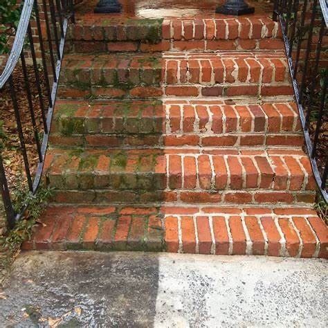 Mossy brick outdoor steps with a black metal railing on the left