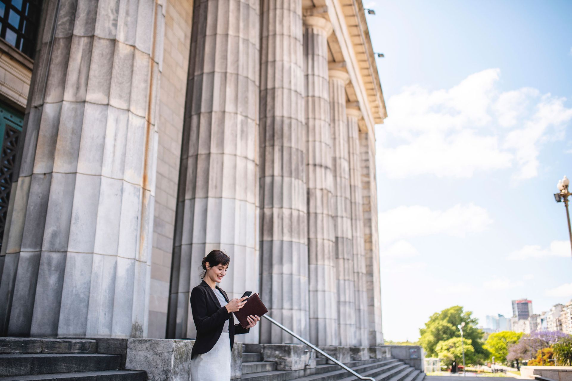A Smiling Woman Outside The Court Office — The Law Offices Of Cardaro & Peek, LLC