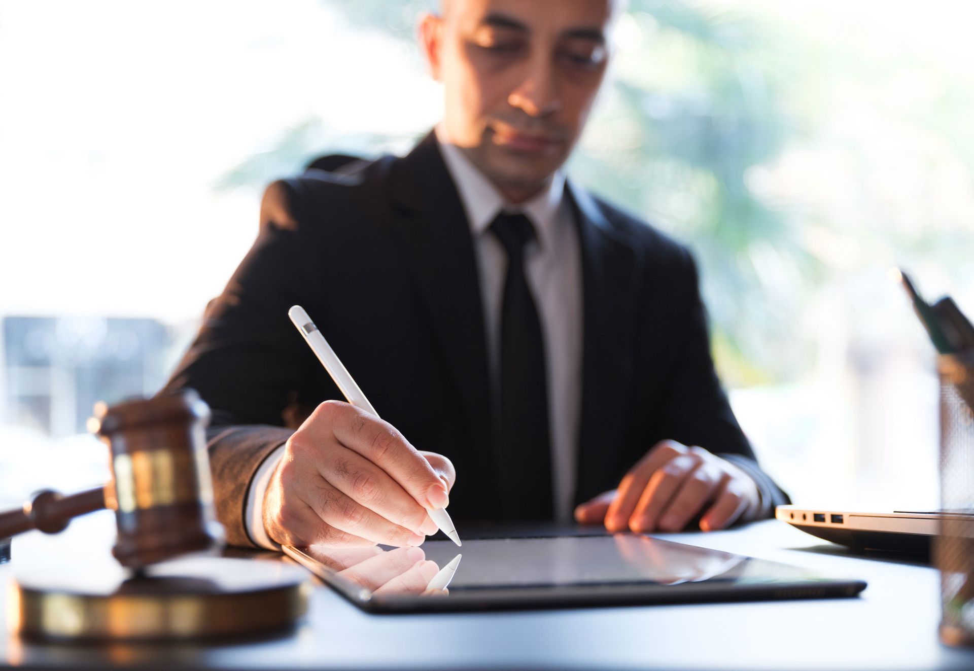 A Man Writing With Digital Pen — The Law Offices Of Cardaro & Peek, LLC