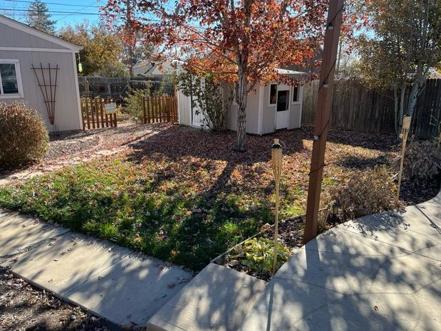 There is a shed in the backyard of a house.