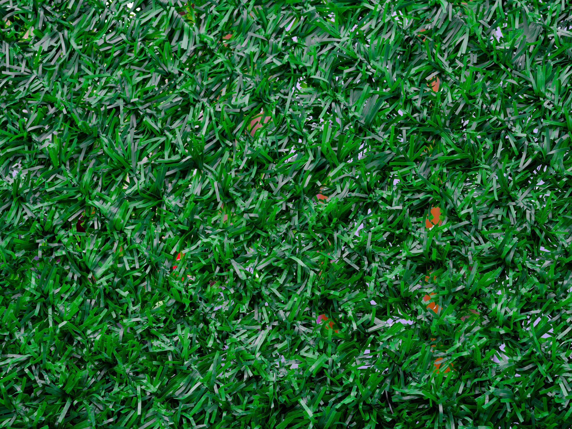 Close-up of vibrant green artificial turf, showing dense, textured blades.