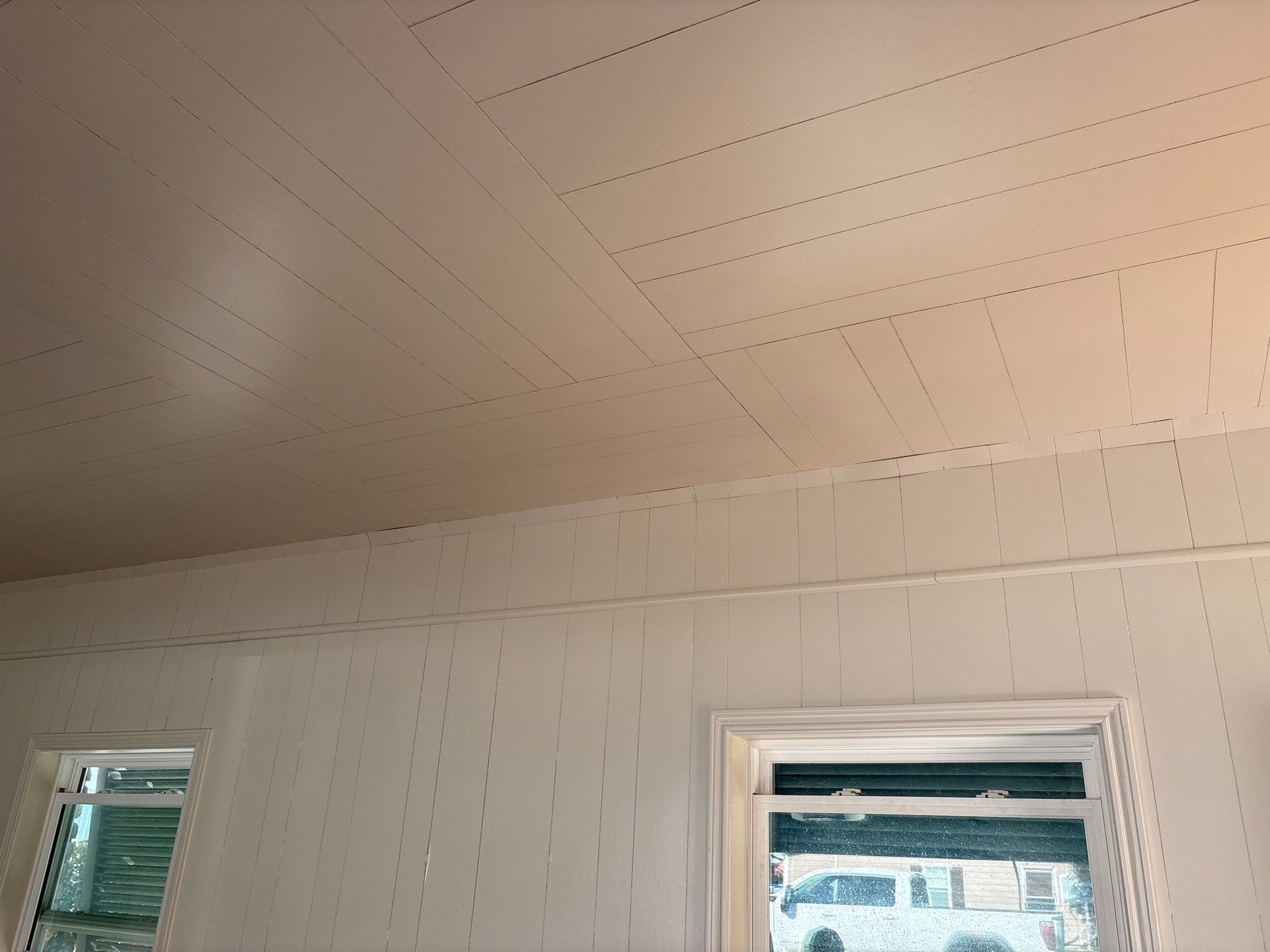 White ceiling and walls, two windows, interior view.