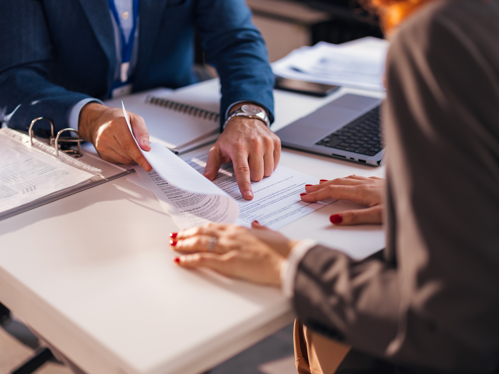 A man and a woman are sitting at a table looking at a piece of paper.
