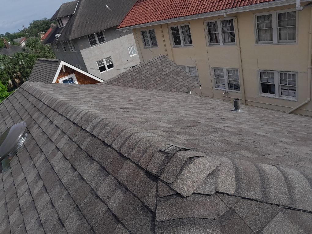 Sloped shingled rooftops on a residential building, viewed from above.