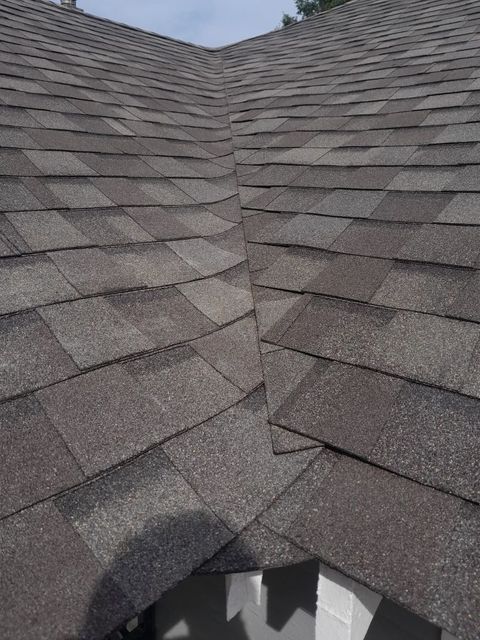 Gray shingled roof with a damaged opening near the bottom center