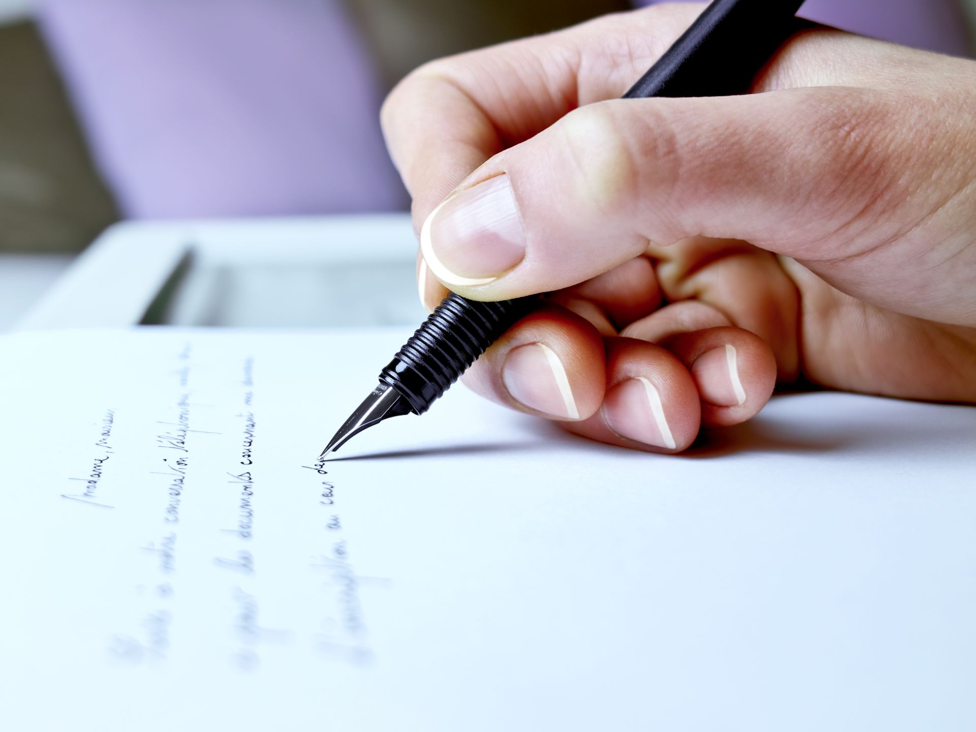 Handwriting Expert examining a signature with a fountain pen on paper Handwriting Expert examining a signature with a fountain pen on paper
