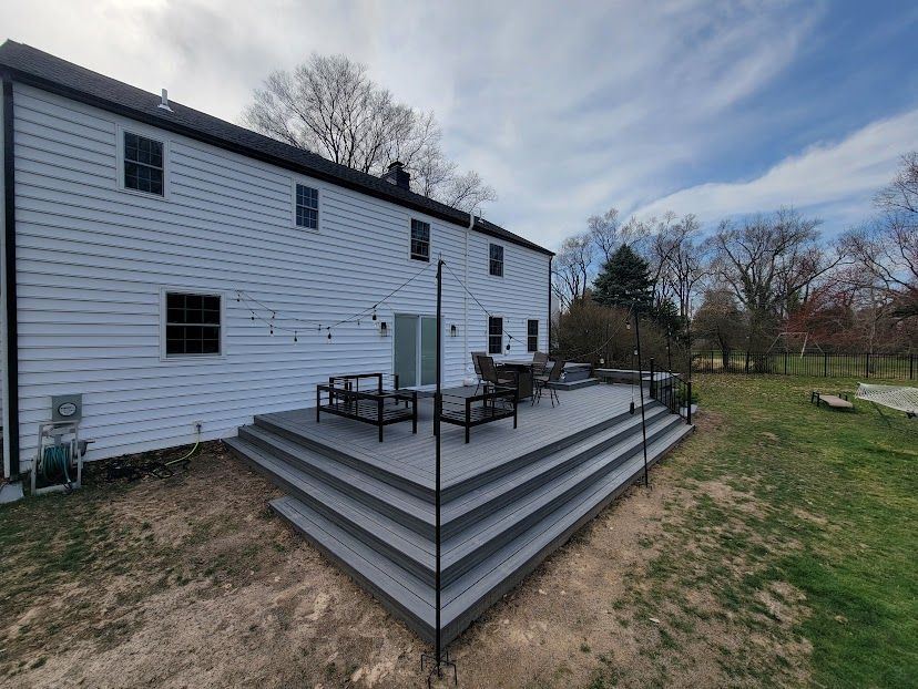 A large white house with a large deck in front of it.