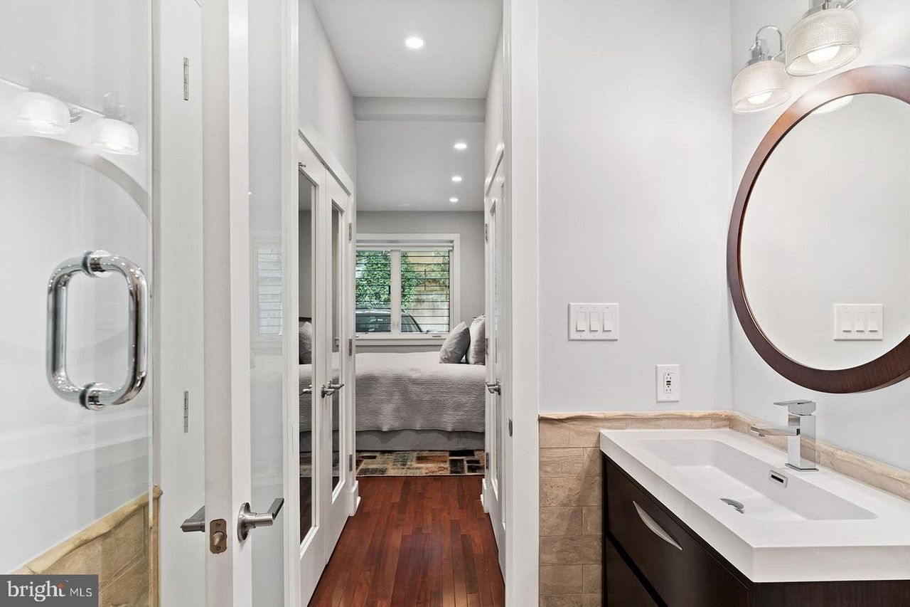 A bathroom with a sink , mirror and walk in closet.