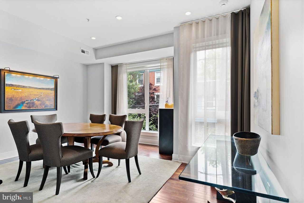 A dining room with a table and chairs and a glass table.
