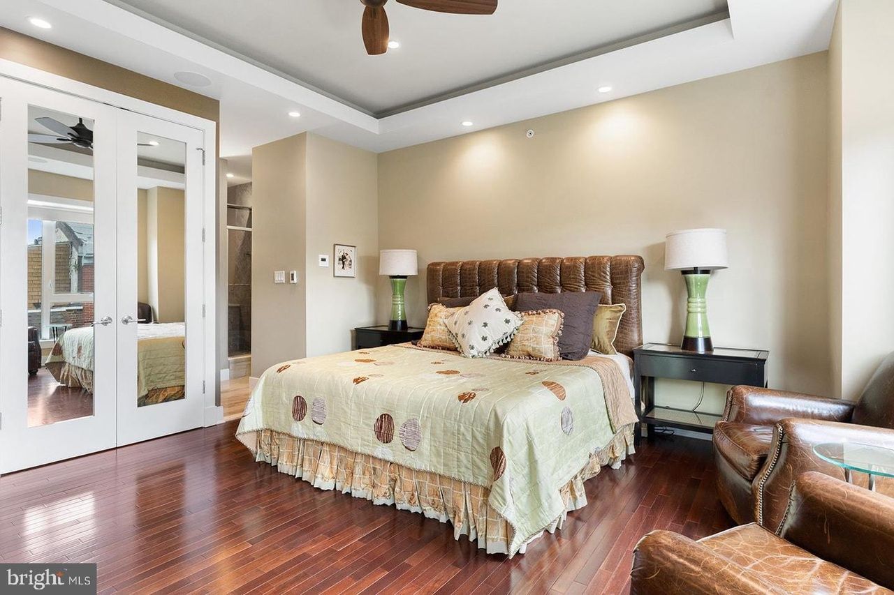 A bedroom with a large bed and a ceiling fan