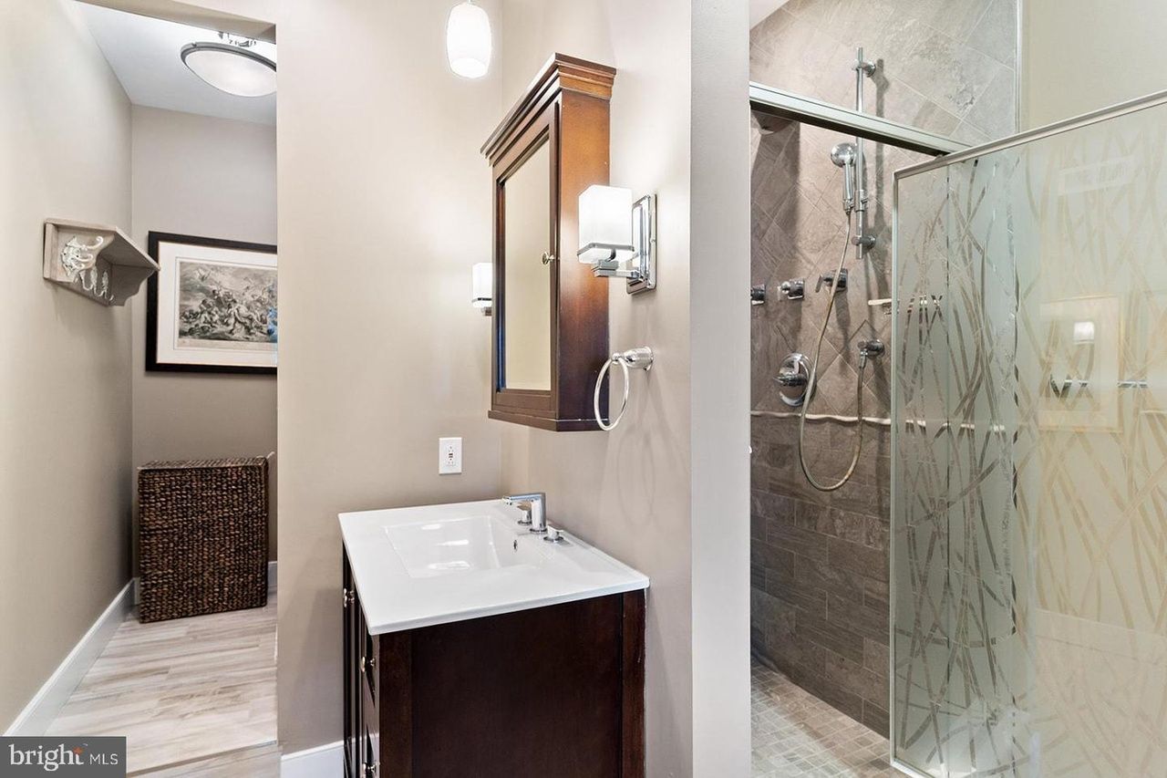 A bathroom with a sink and a walk in shower.
