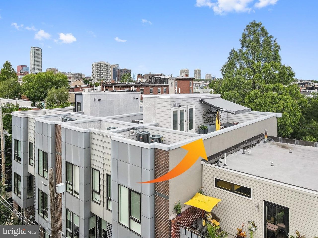 An aerial view of a building with a yellow arrow pointing to the roof
