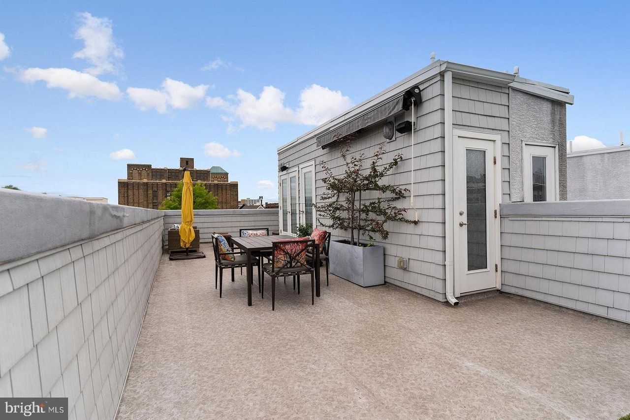 A rooftop deck with a table and chairs on it