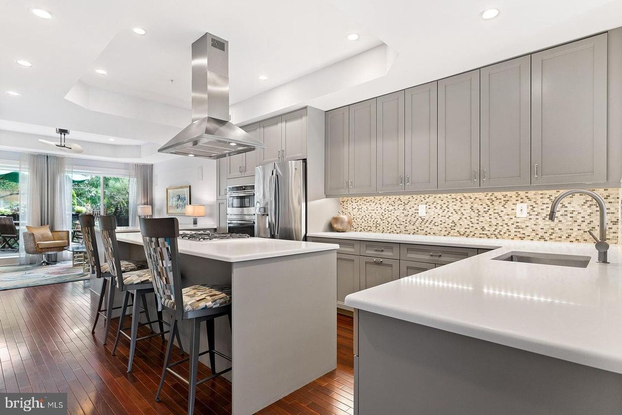 A kitchen with gray cabinets and white counter tops