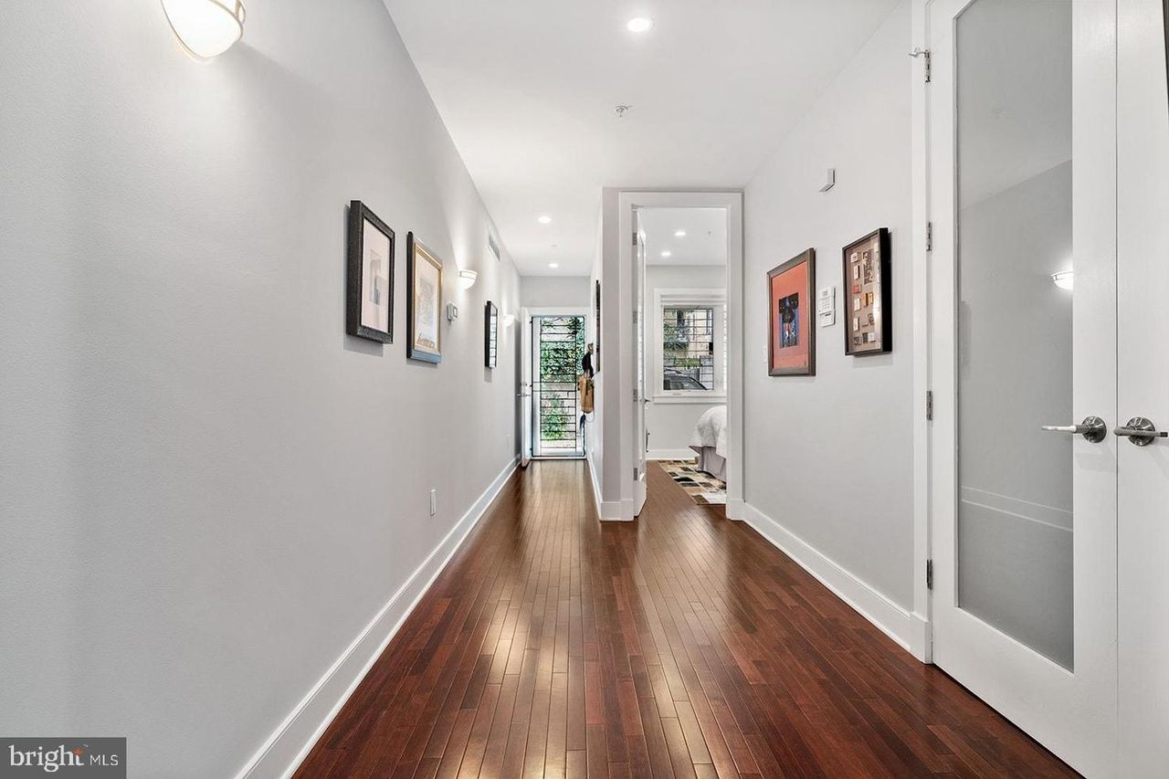 A long hallway with hardwood floors and white walls