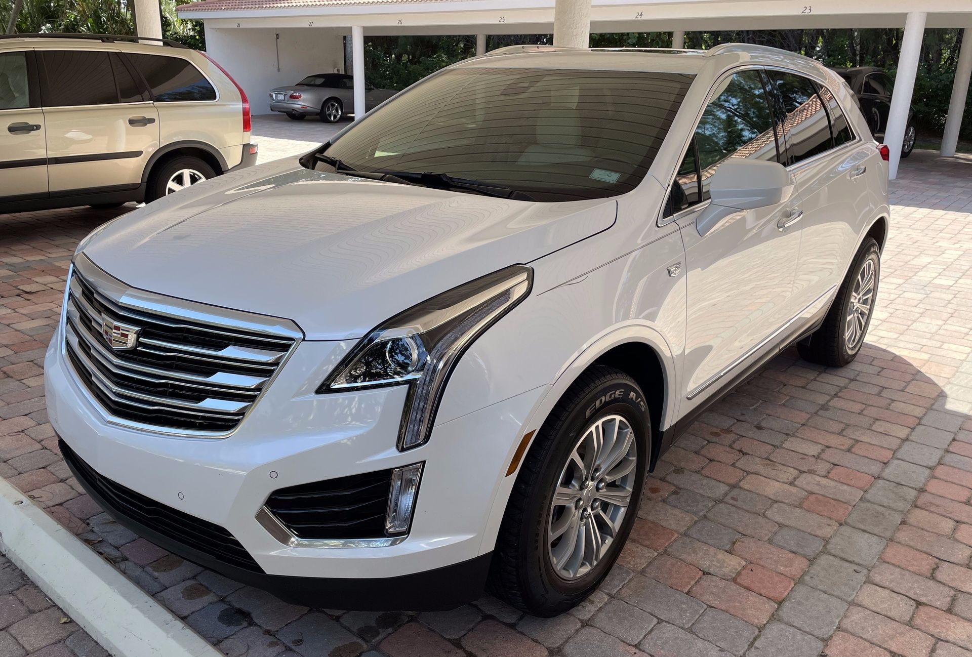 a white cadillac is parked in a parking lot .