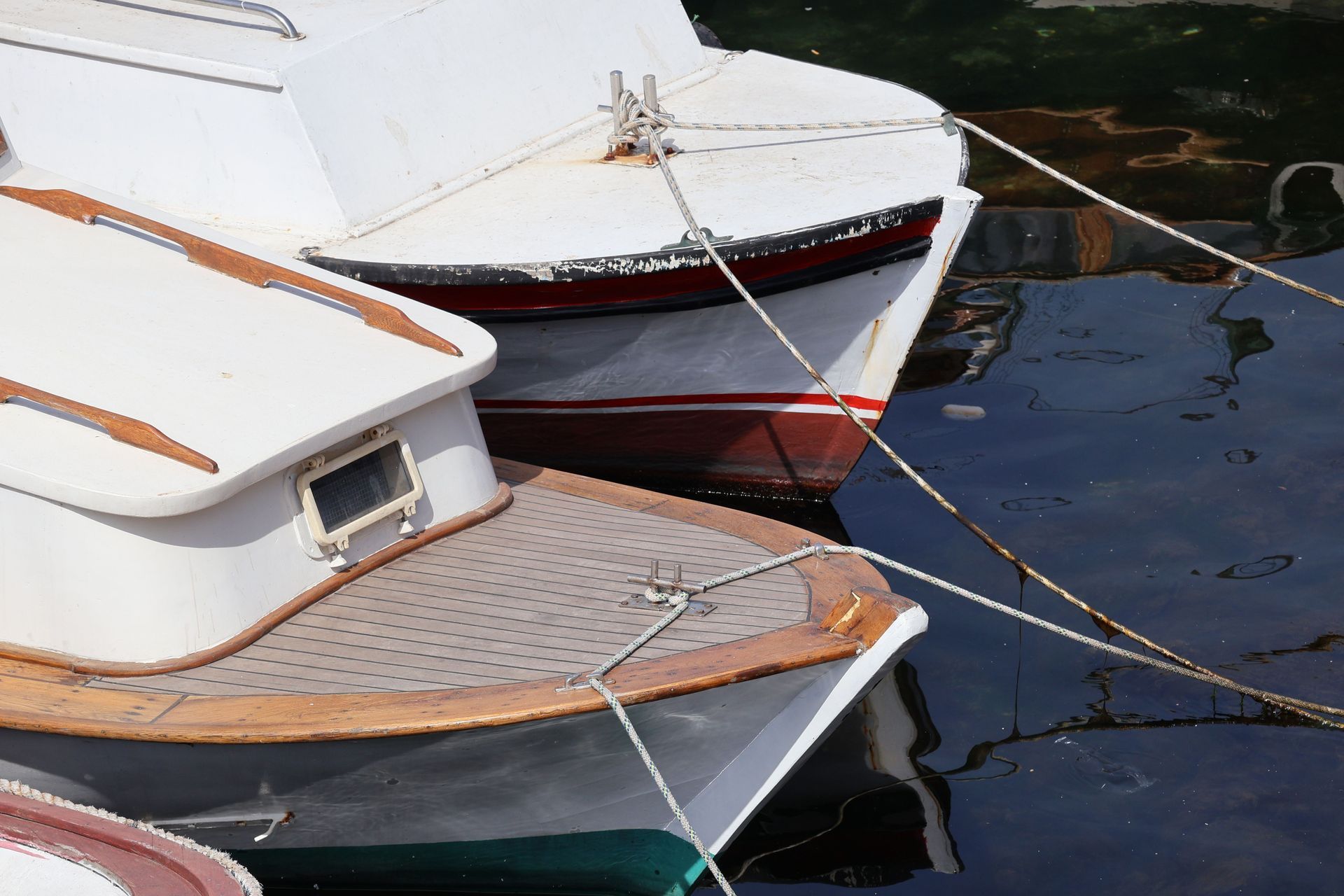 Boat steering wheel and windshield on a blue-and-white motorboat, with water in the background