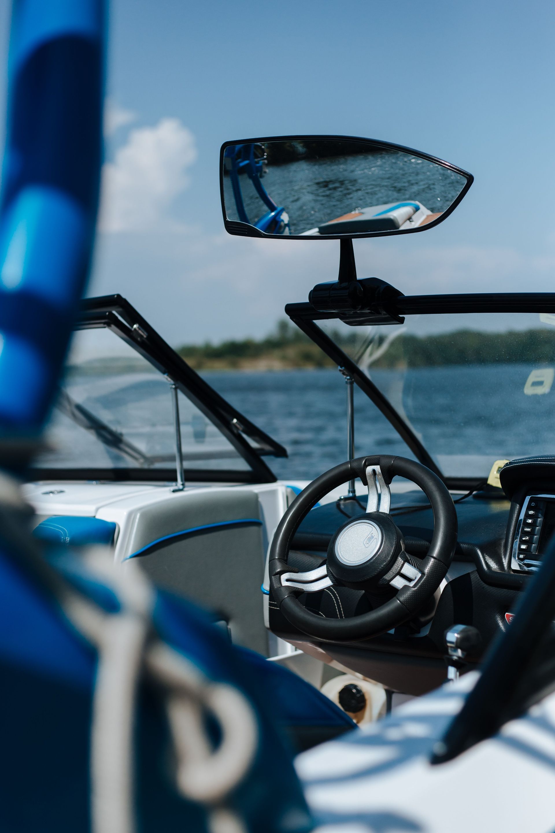 White center-console boat cockpit with beige seating, tabletop, and black canopy on the water