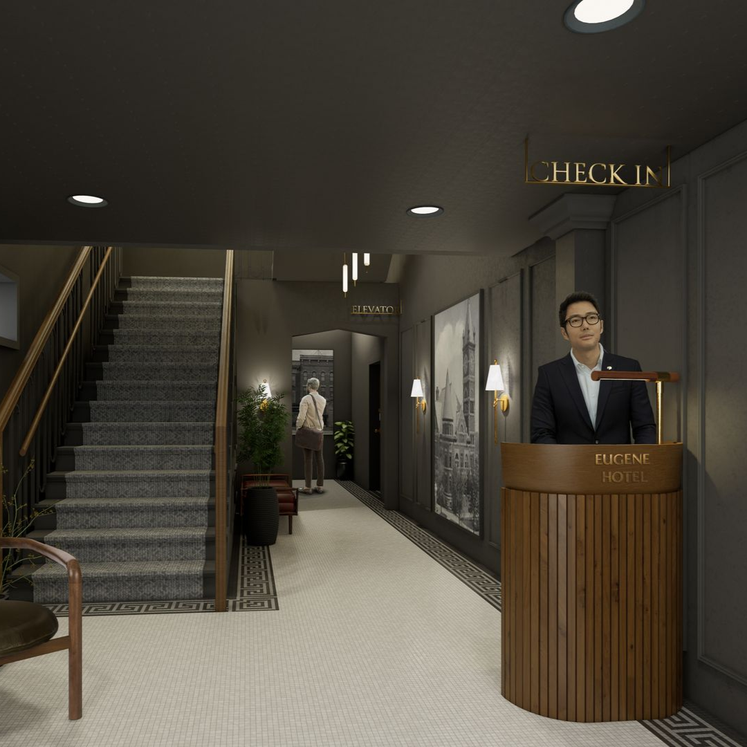 A person stands behind a wooden hotel check-in desk in a dimly lit, modern lobby with a staircase and a patterned floor.