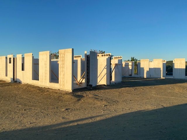 A row of concrete walls in a field with a blue sky in the background