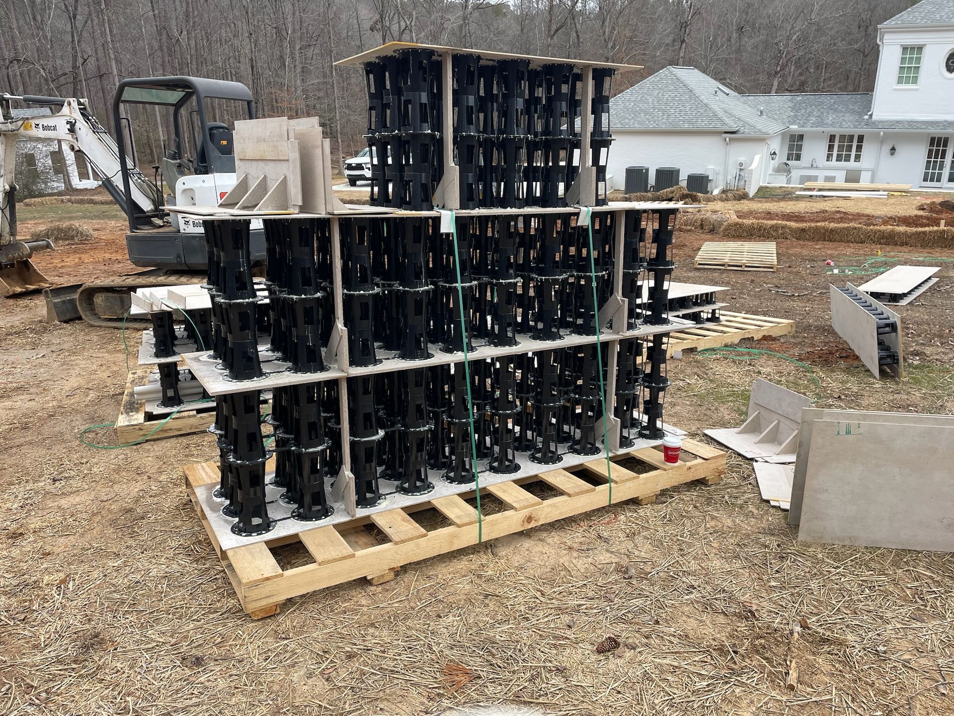 A wooden pallet filled with concrete blocks is sitting on top of a dirt field.