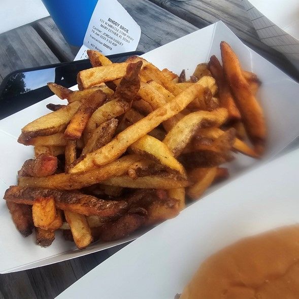 A tray of french fries sits on a table.