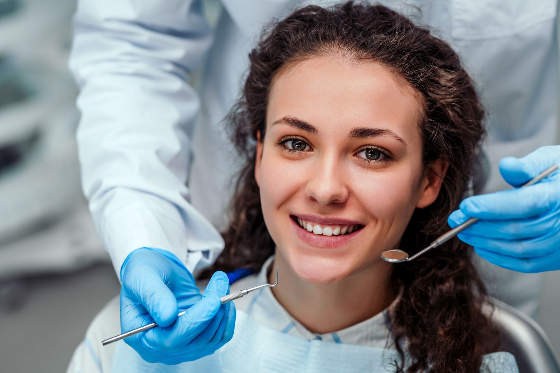 A general dentist is examining a patient's teeth using dental tools. A general dentist is examining a patient's teeth using dental tools.
