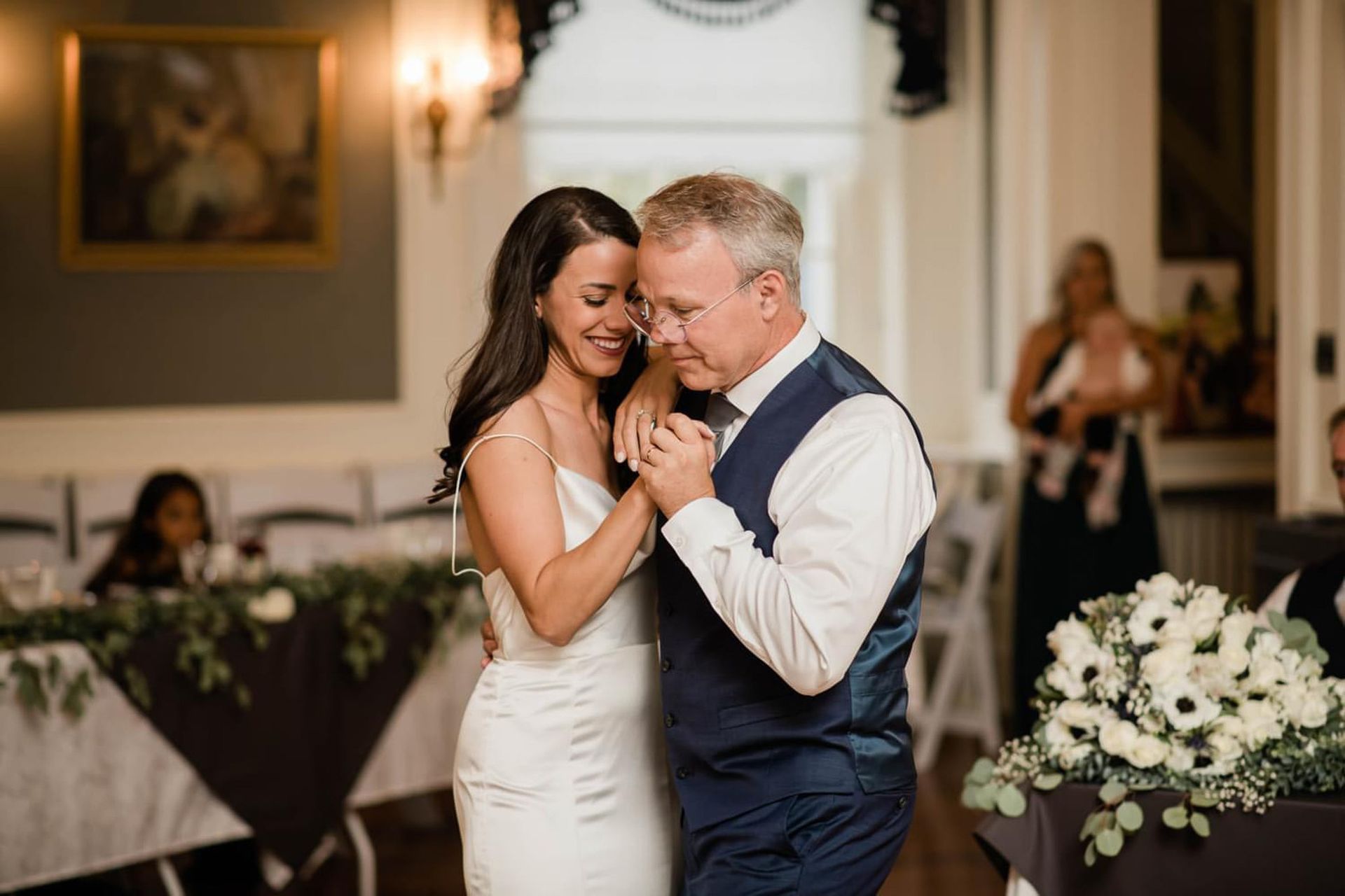 A bride and groom are dancing together at their wedding reception.