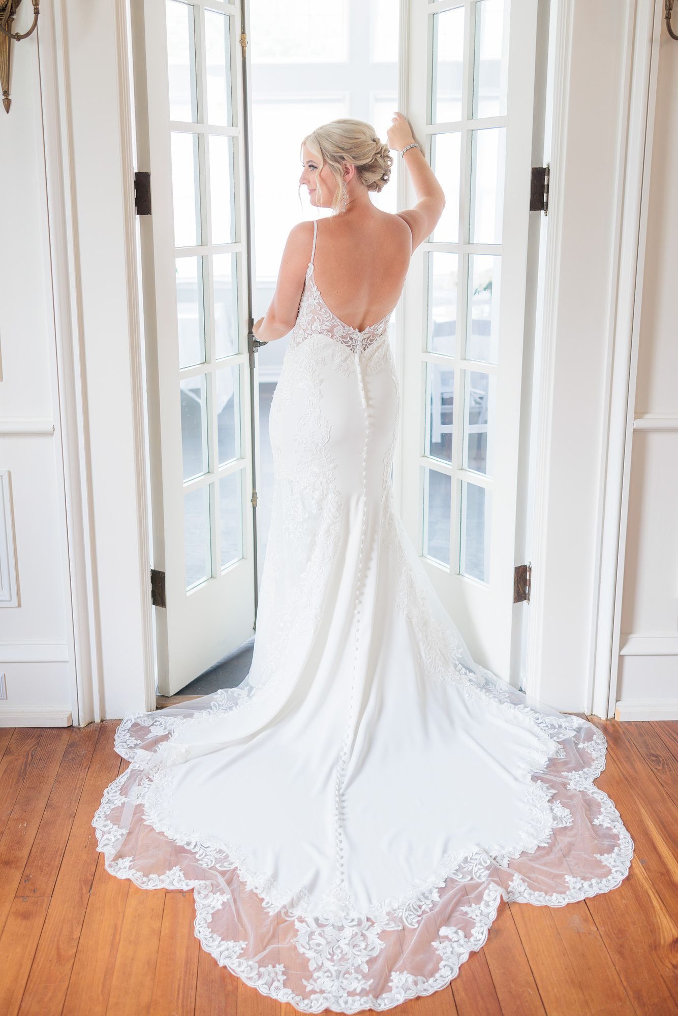 A bride in a wedding dress is standing in front of a door.