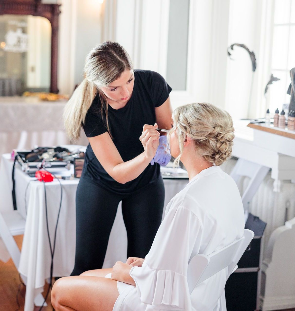 A woman is applying makeup to another woman 's face