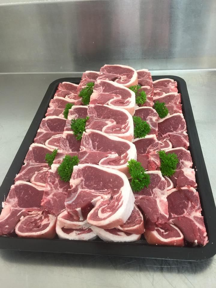 A Tray of Raw Lamb Chops with Parsley on A Table — Holiday Coast Meat & Smallgoods in South Grafton, NSW