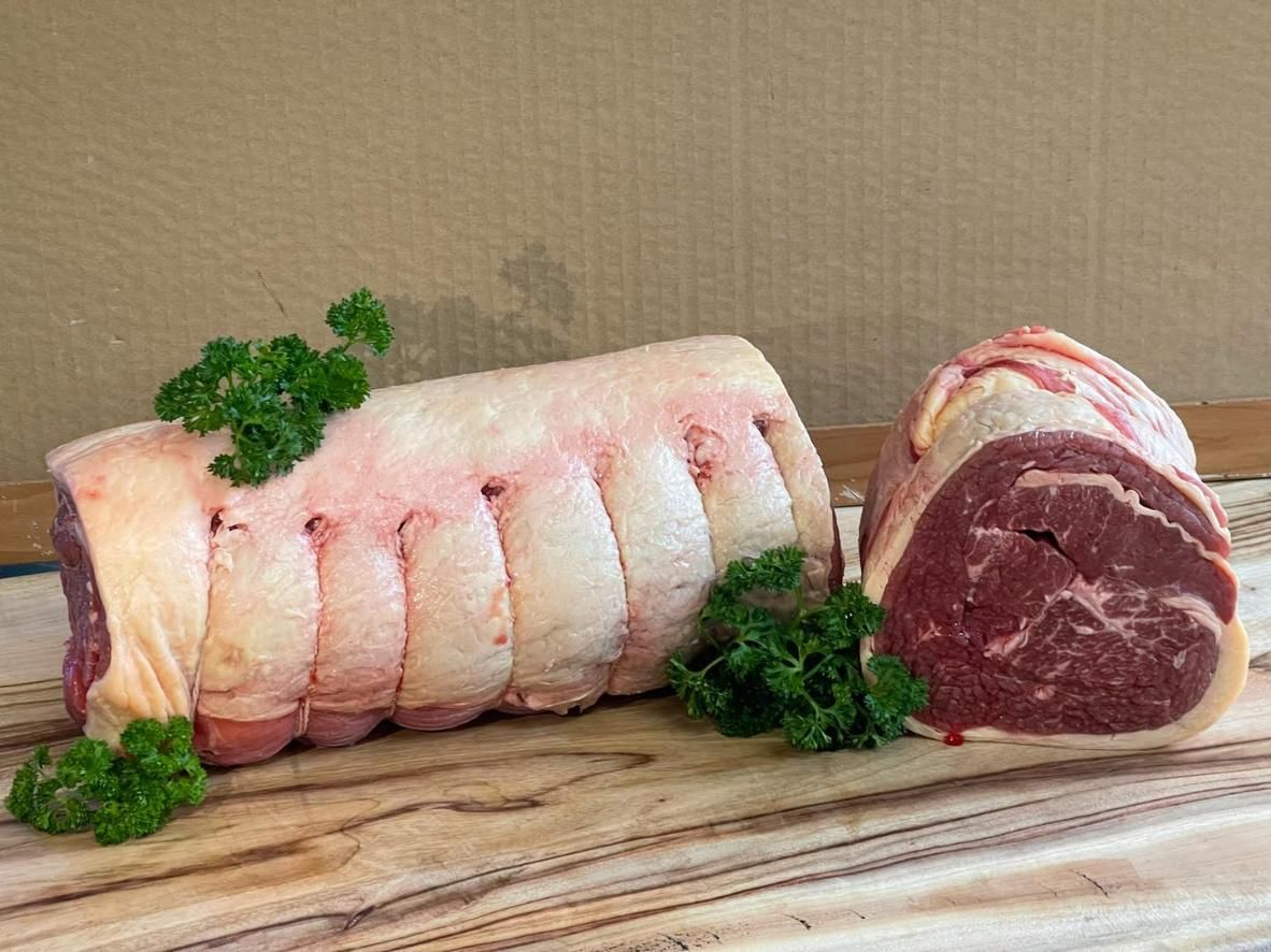 Two Pieces of Raw Beef Are Sitting on A Wooden Cutting Board — Holiday Coast Meat & Smallgoods in Grafton, NSW