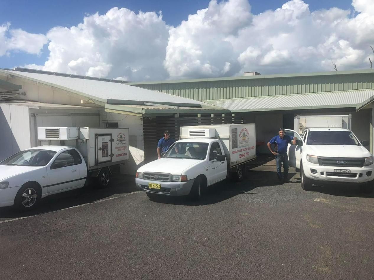 A Group of White Trucks Parked in Front of A Building — Holiday Coast Meat & Smallgoods in South Grafton, NSW