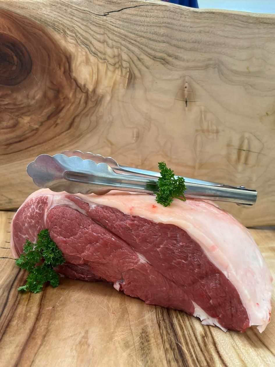 A Piece of Raw Beef Is Sitting on A Wooden Cutting Board — Holiday Coast Meat & Smallgoods in South Grafton, NSW