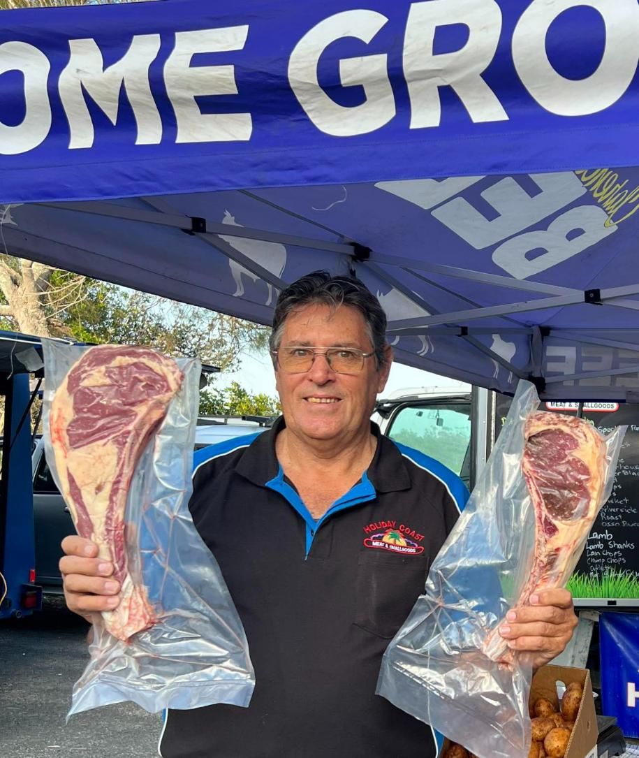 A Man Is Holding Two Bags of Meat — Holiday Coast Meat & Smallgoods in South Grafton, NSW