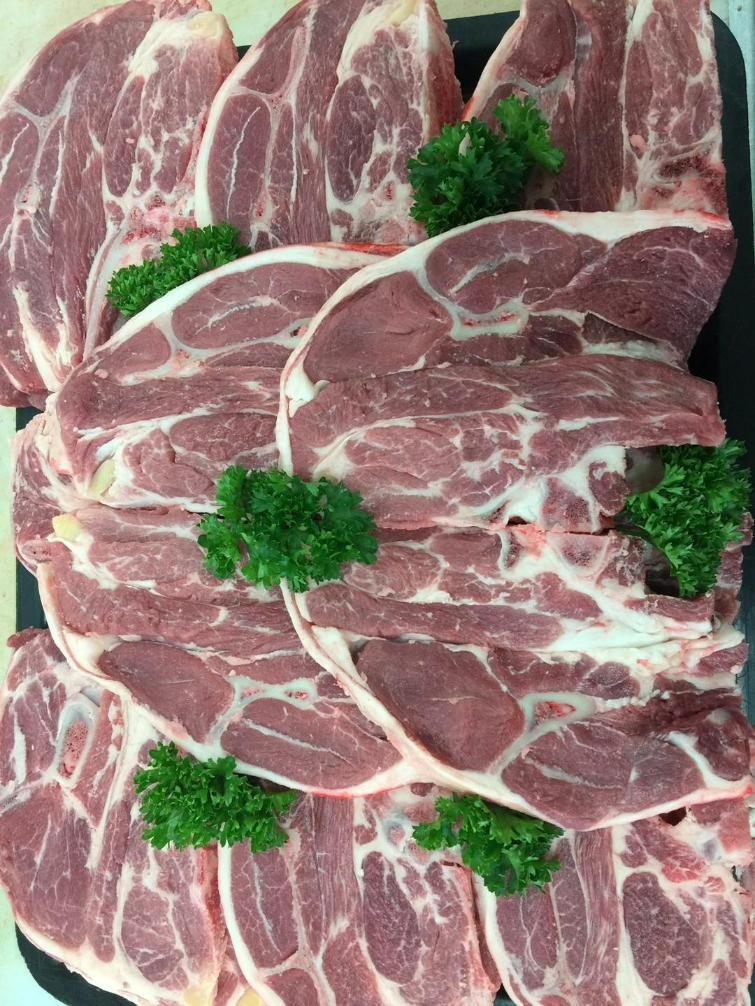 A Pile of Raw Lamb Chops with Parsley on A Cutting Board — Holiday Coast Meat & Smallgoods in South Grafton, NSW