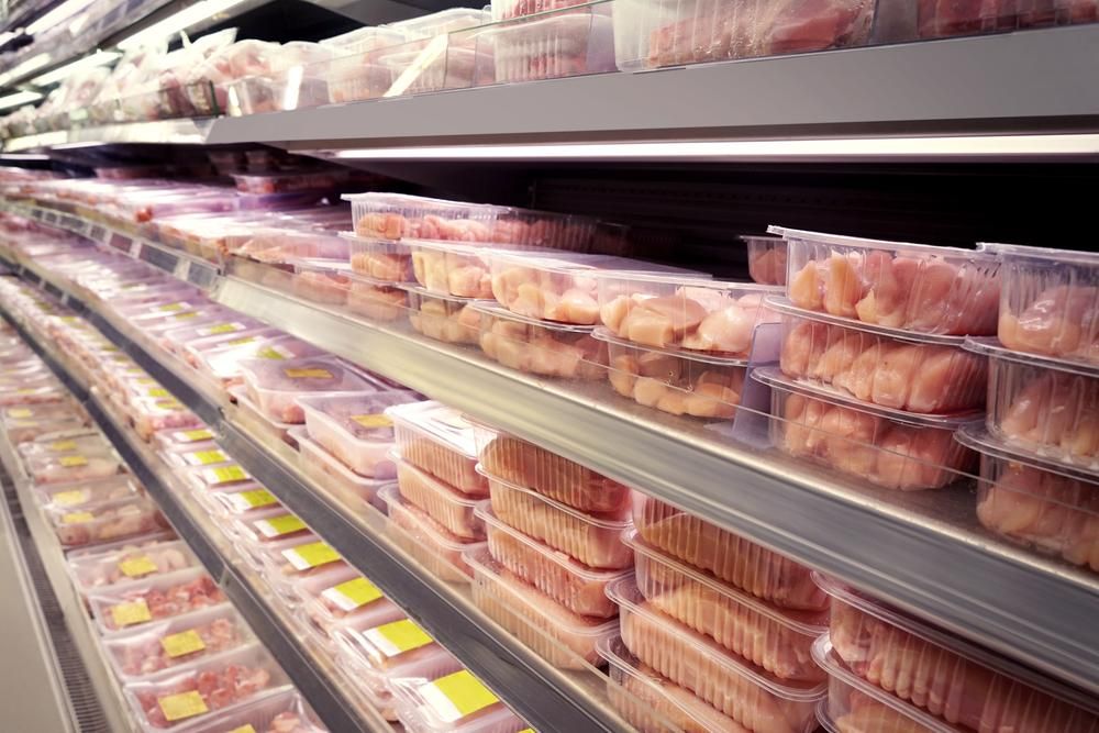A Grocery Store Aisle Filled with Lots of Chicken in Plastic Containers — Holiday Coast Meat & Smallgoods in Glenn Innes, NSW