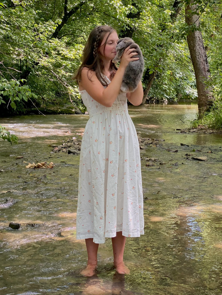 Girls Holding Pet Bunny Rabbit While Standing Outside in Creek