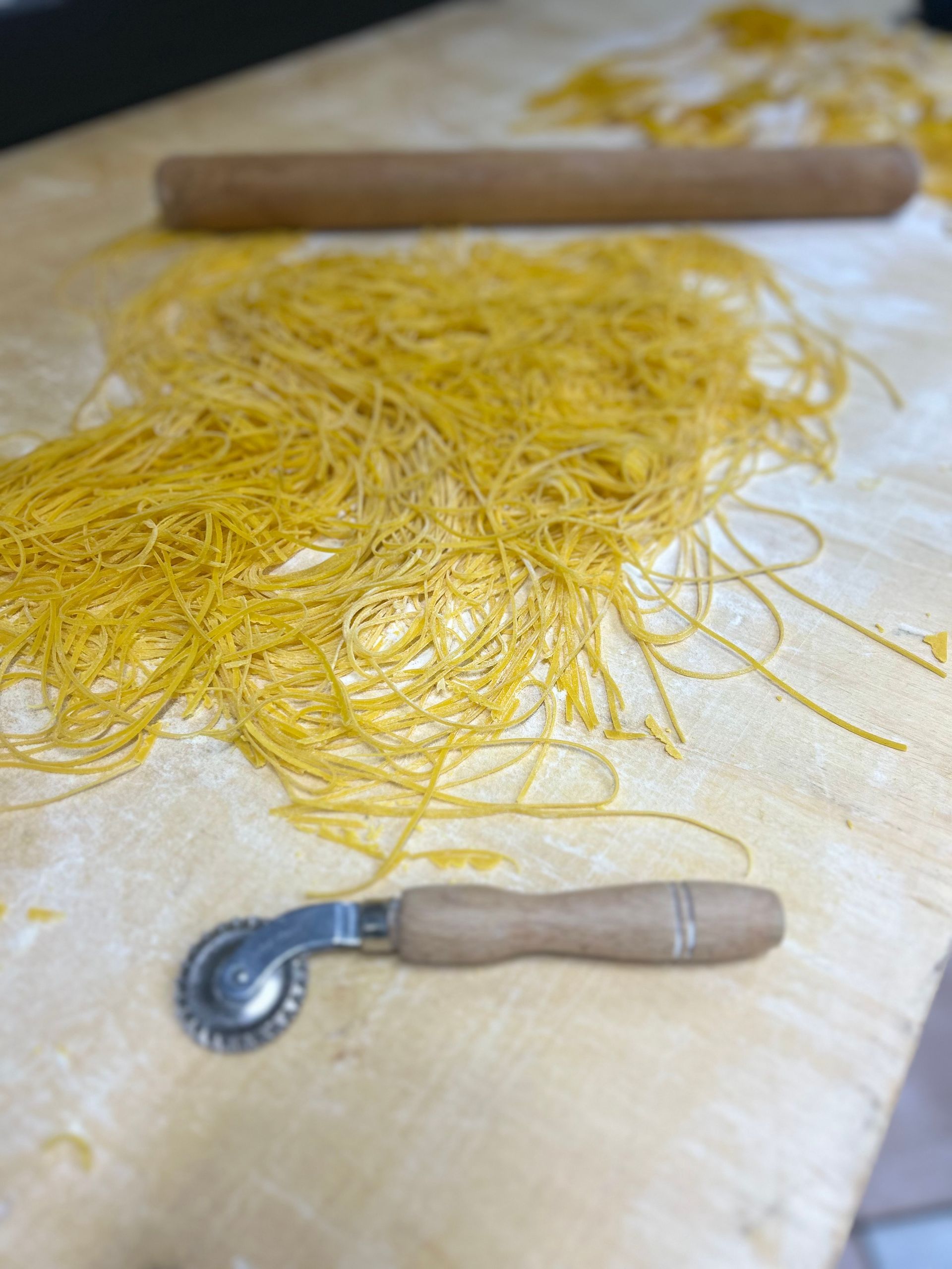 Stendere i fili di pasta fresca su una spianatoia infarinata con una rotella tagliapasta e un mattarello.