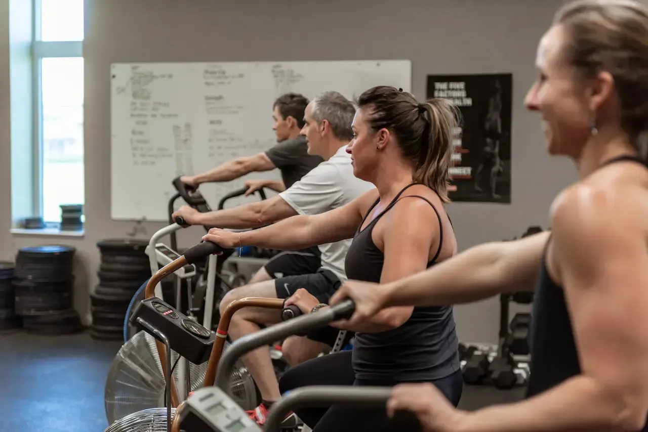 People on stationary bikes at a gym, exercising.