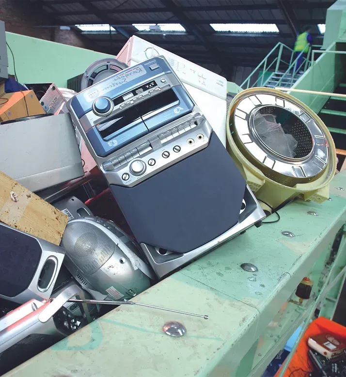 Pile of discarded electronics including a car stereo.