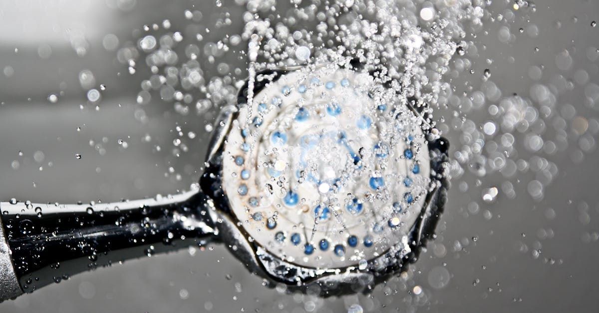 Shower head spraying water; gray and blue tones.